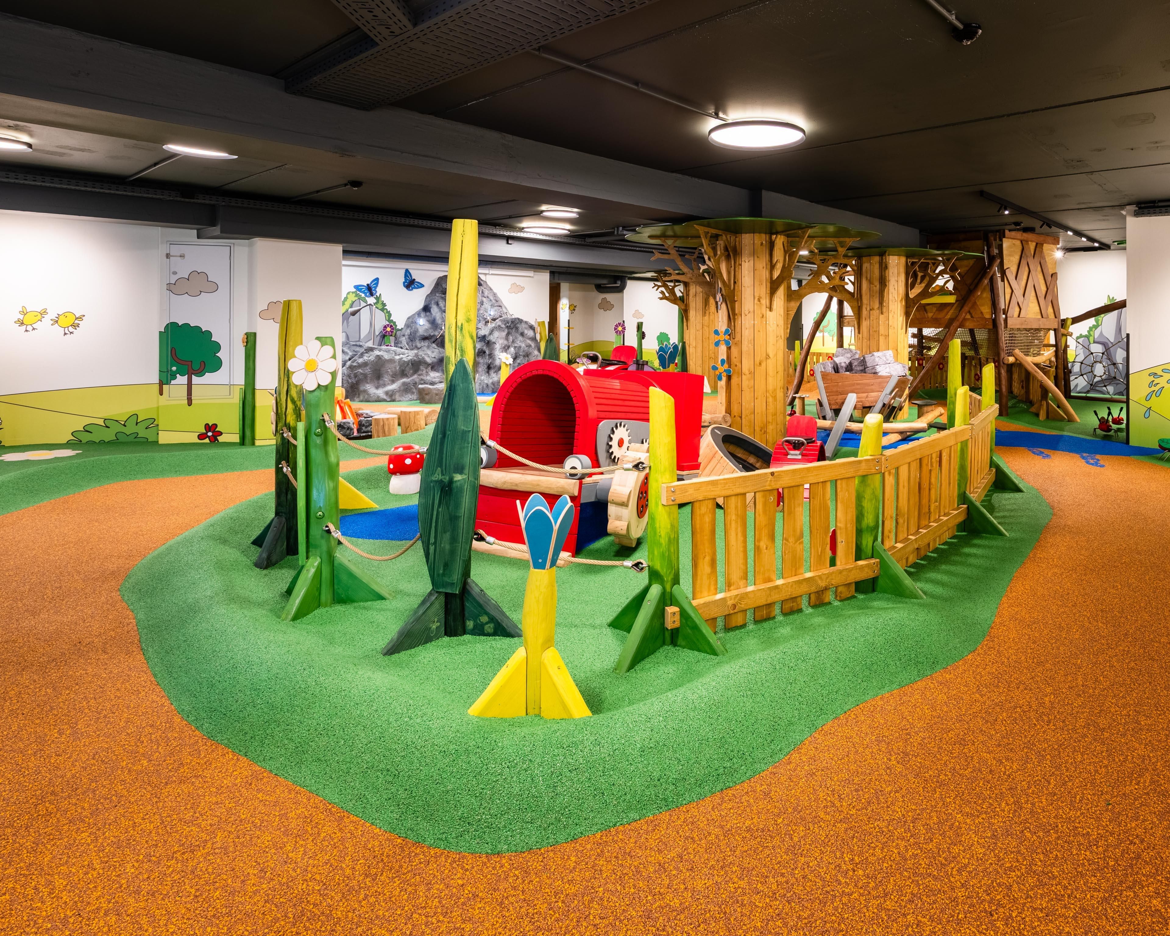 A colorful adventure play area for little explorers with a colorful tractor and many other play highlights