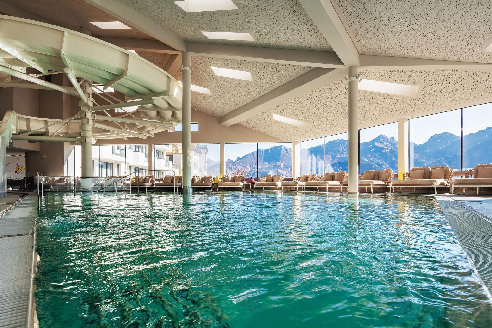 Family water world with family pool. A modern swimming pool, large window front offering a view of the mountains.