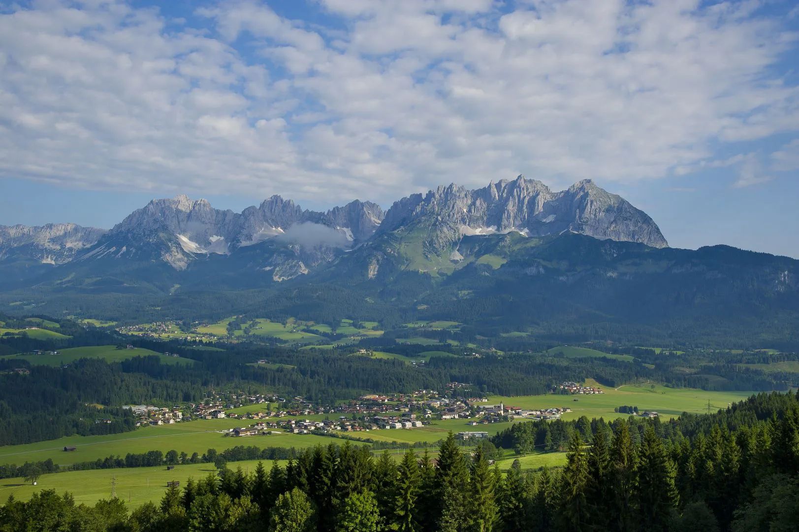 Wilder Kaiser im Sommer mit dem Ort Oberndorf im Vordergrund