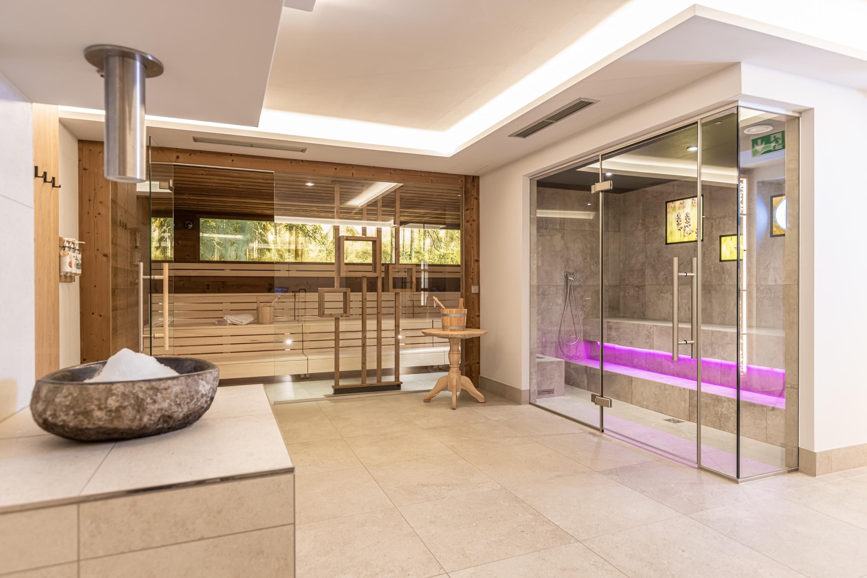 A modern wellness area with a sauna and a steam shower. The room is designed to be friendly and bright, ideal for relaxation.