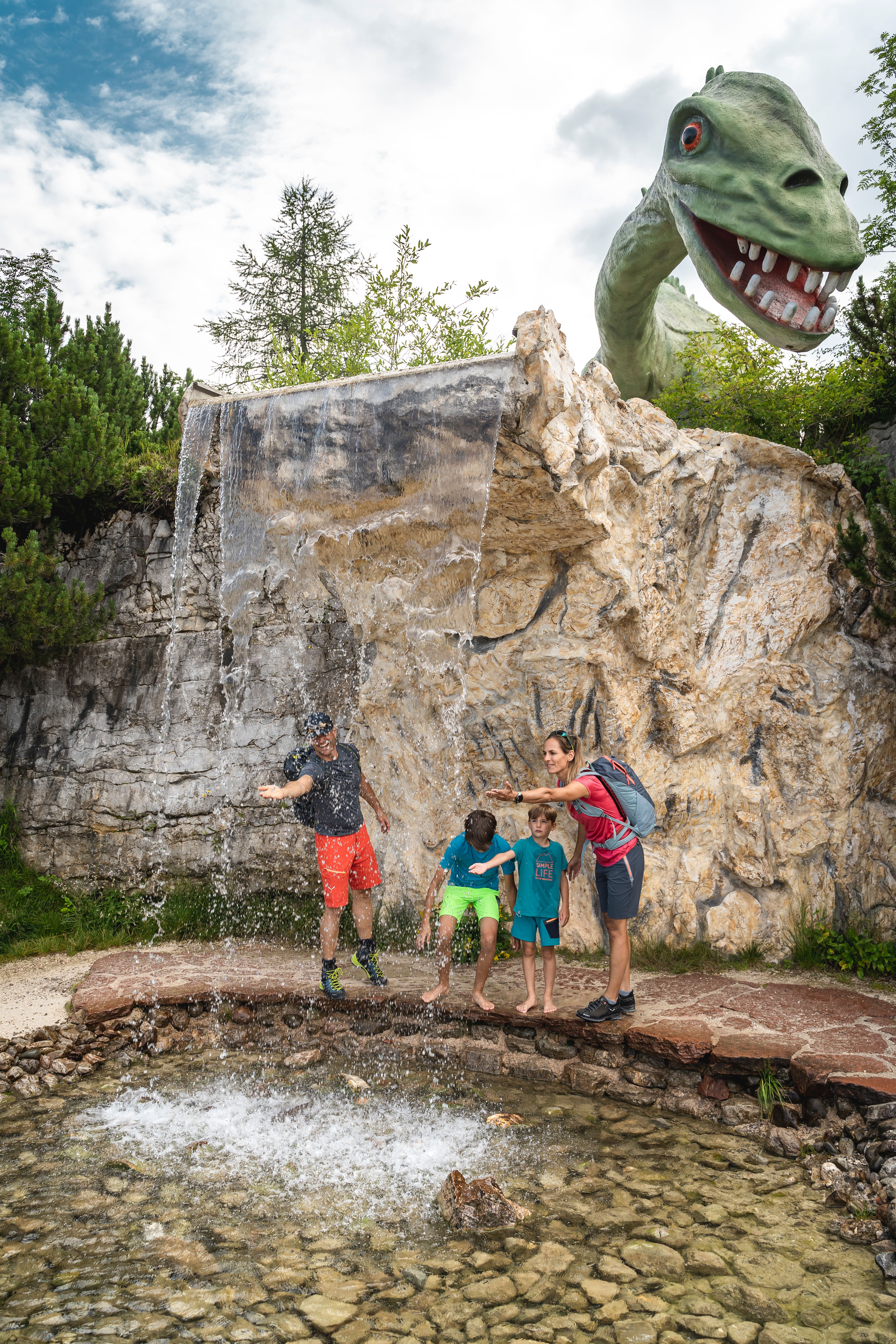 Triassic Park Steinplatte Waidring, Dinosaurier Figur mit spielenden Kindern