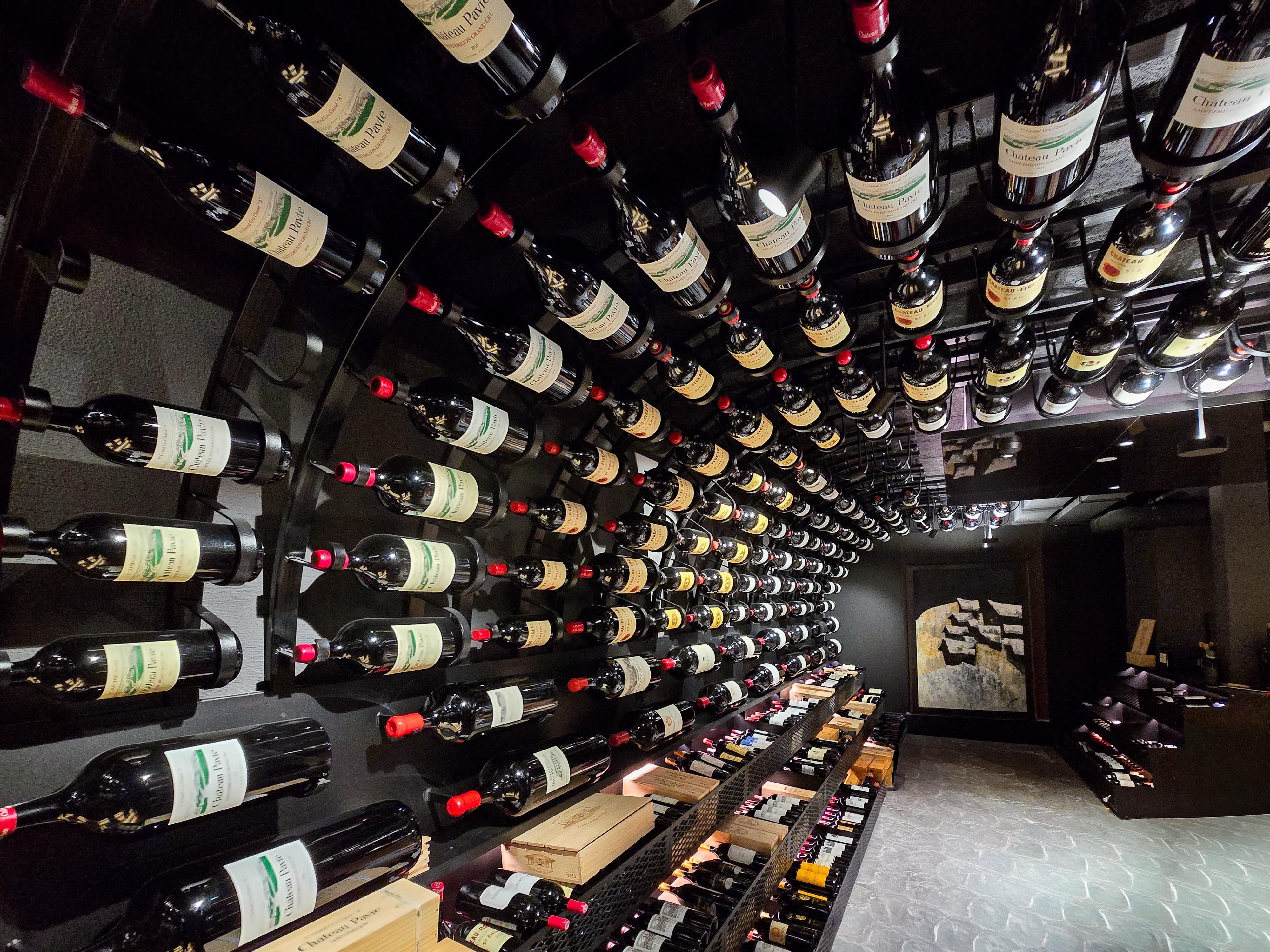 A wine cellar with many bottles of red wine hanging on a round wall. The atmosphere is elegant and inviting.
