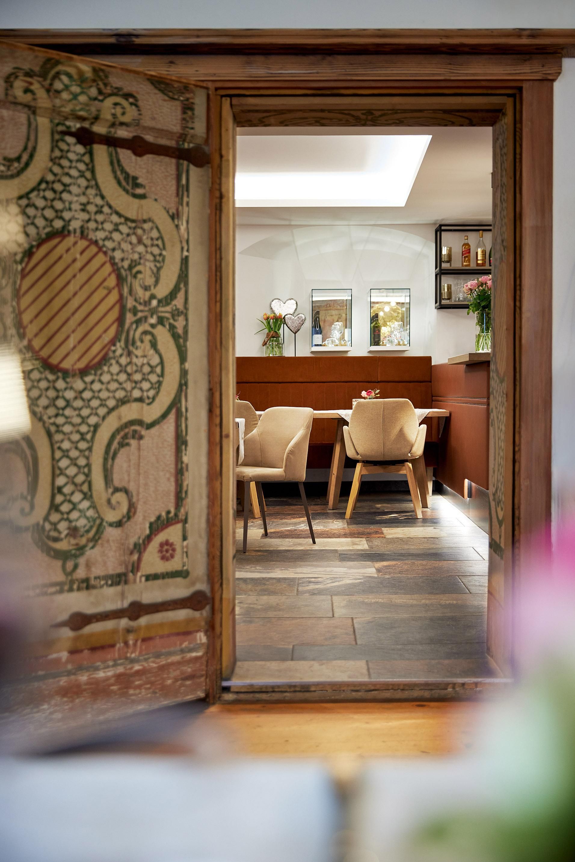 An inviting room with a decorative entrance. In the background, elegant chairs and a bright, friendly atmosphere can be seen.