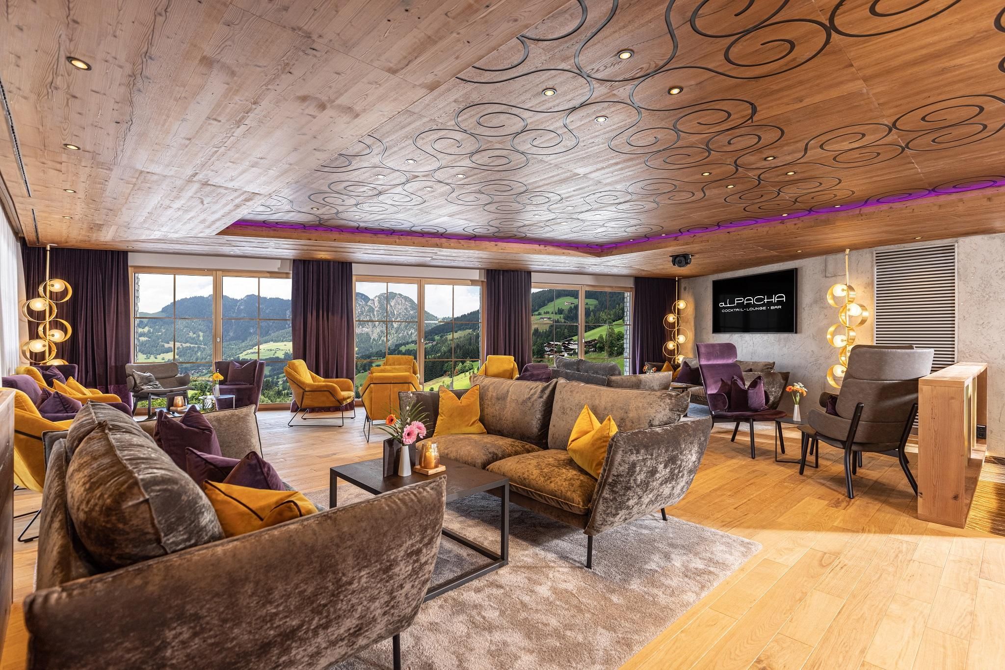 A modern living room with stylish furniture and a magnificent view of the mountains. Large windows provide plenty of natural light and a cozy atmosphere.