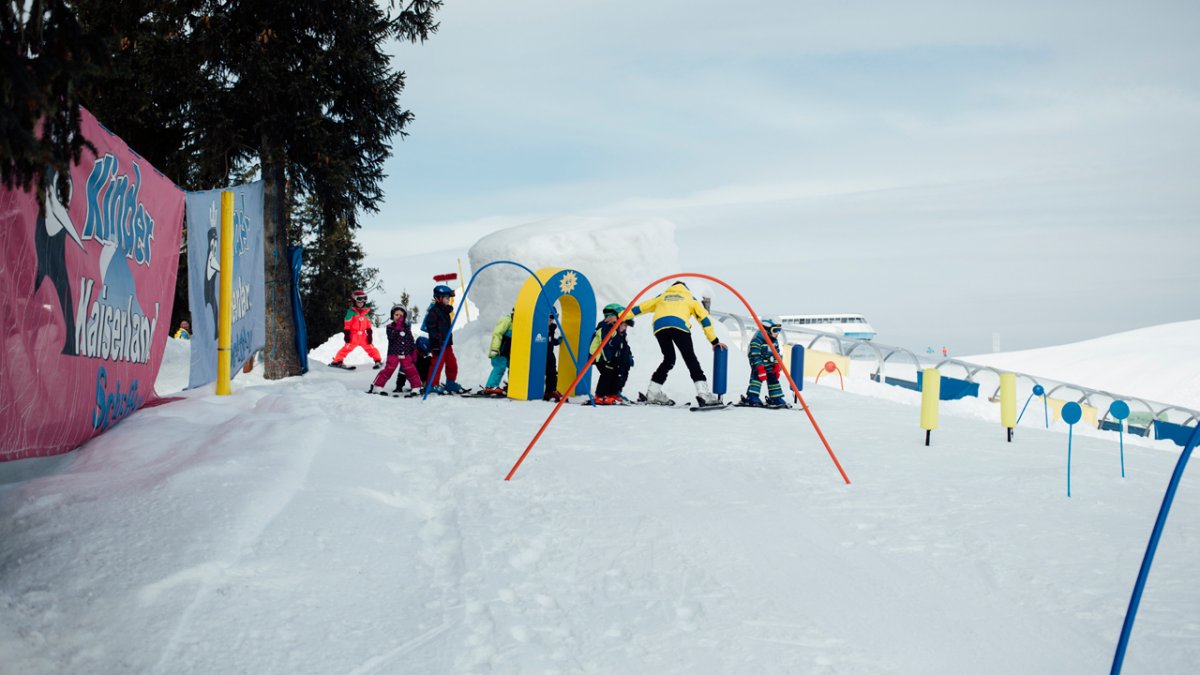 Każda szkoła narciarska ma własną strefę dla początkujących z łatwo dostępnymi wyciągami taśmowymi i pomocami do nauki, takimi jak tory do slalomu giganta i karuzele narciarskie., © Tirol Werbung/Fritz Beck
