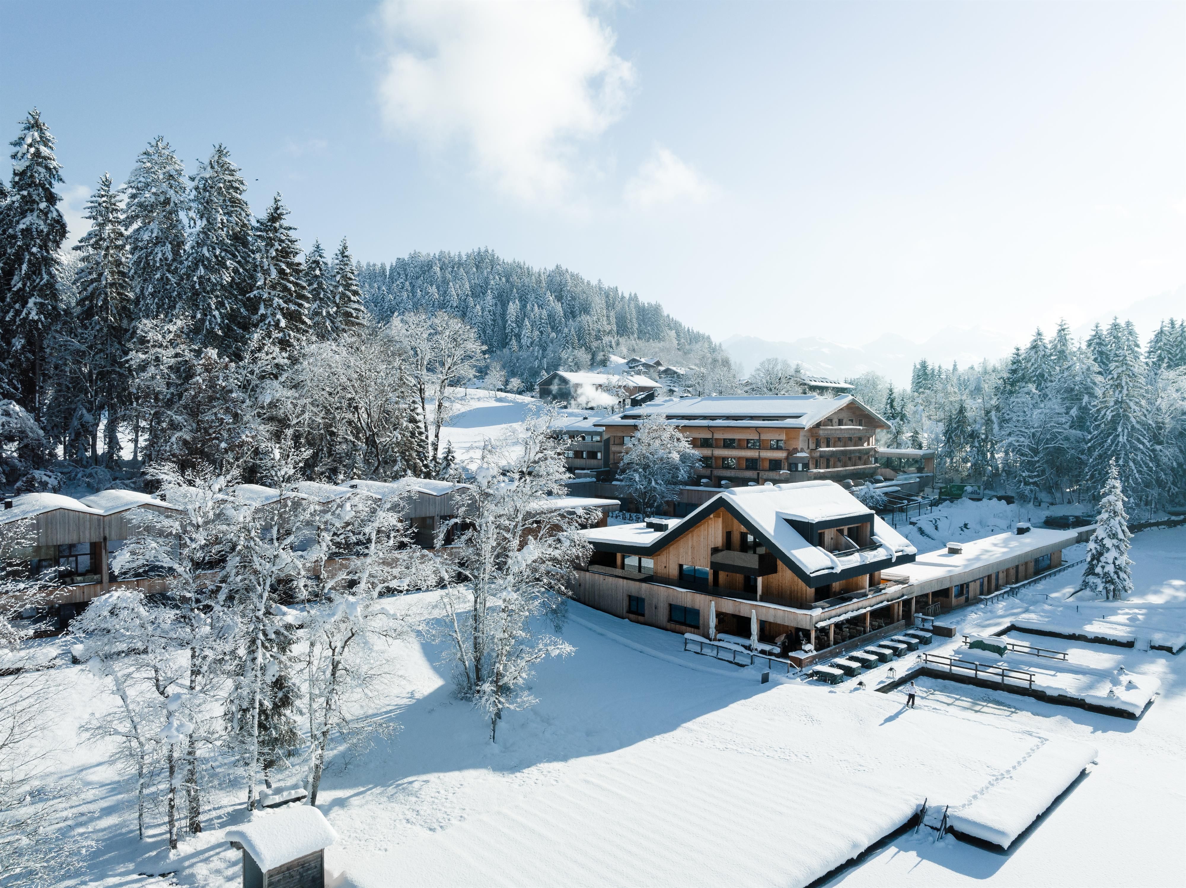 <p>The picturesque Alpine hotel by the Schwarzsee, surrounded by snow-covered mountains and fir trees. In front of the hotel lies the snow-covered Schwarzsee.</p>