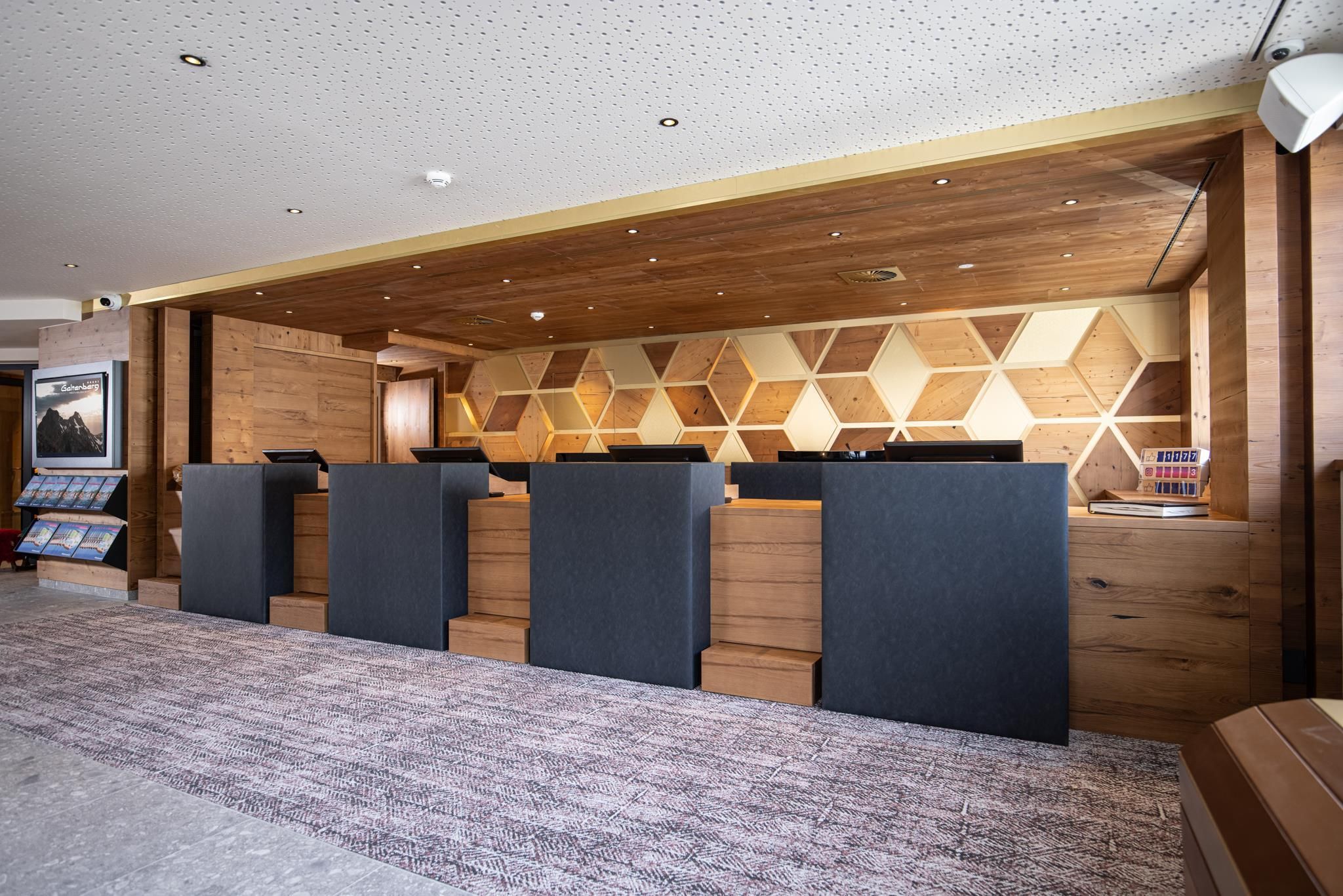 A modern designed reception area with an elegant wooden cladding. The reception counters are designed in a clear, minimalist style.
