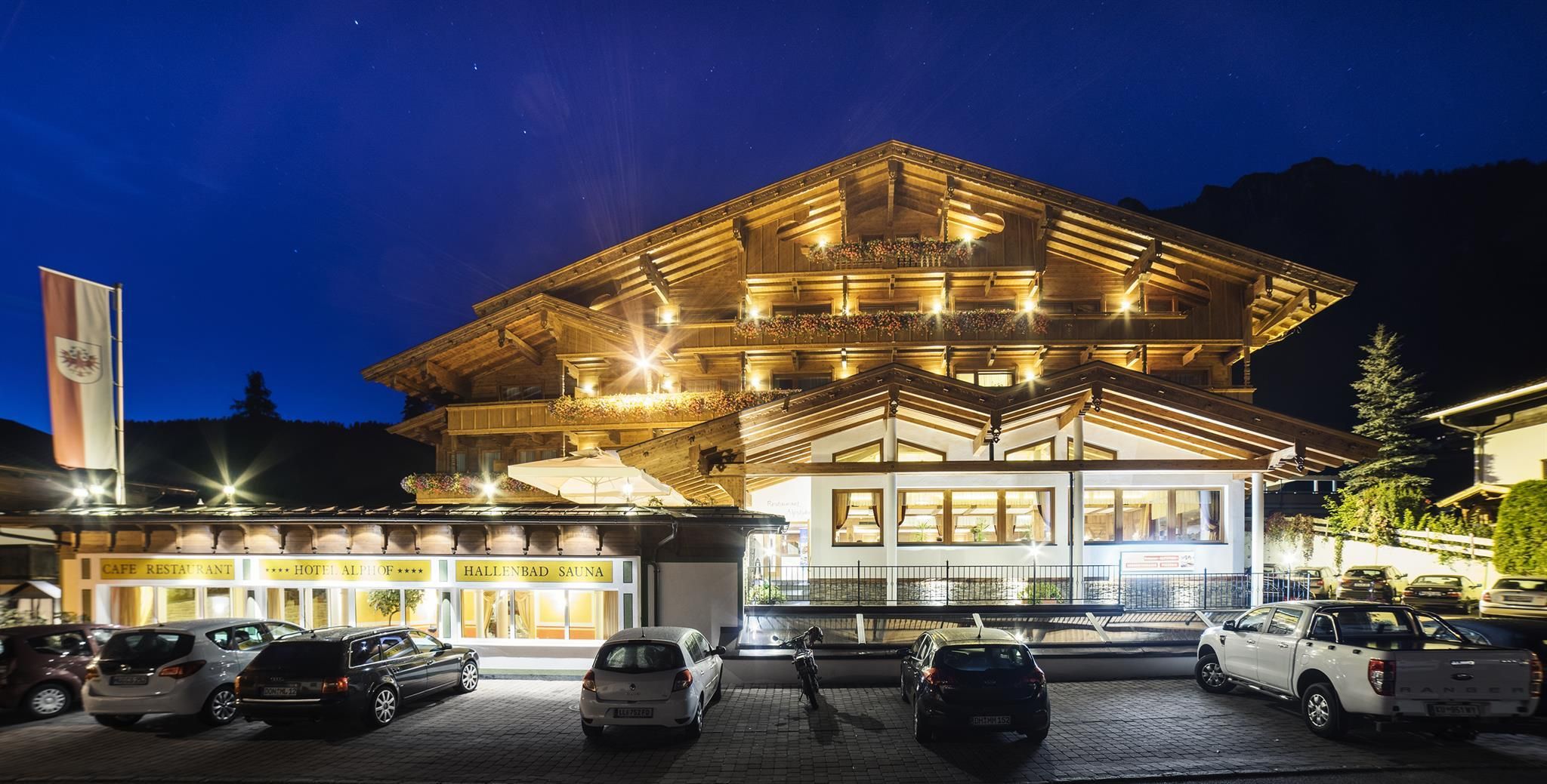 Hotel Alphof with outdoor view at night, illuminated balconies with terrace.